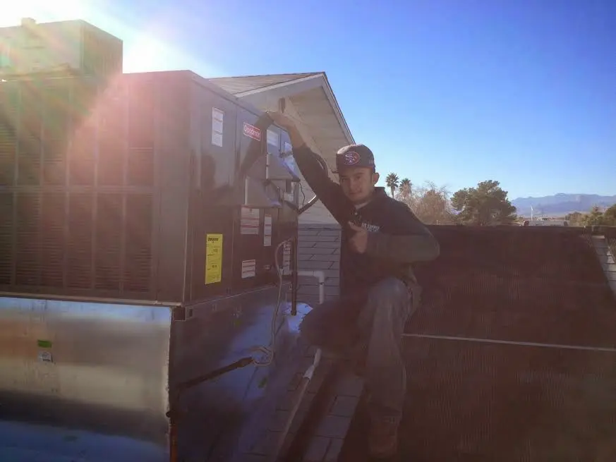 HVAC technician performing AC Tune-Up on a rooftop unit in Montclair